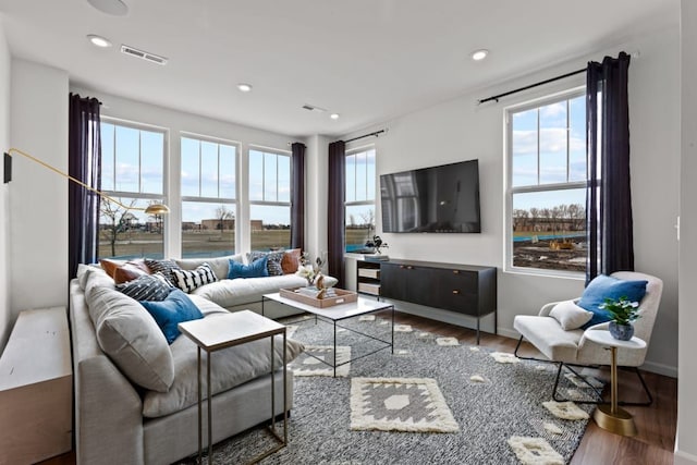 living area featuring baseboards, wood finished floors, visible vents, and recessed lighting