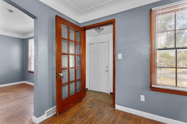 entryway with crown molding, dark wood-type flooring, and a healthy amount of sunlight