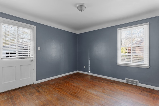 empty room with plenty of natural light and dark wood-type flooring