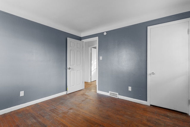 unfurnished room with dark wood-type flooring