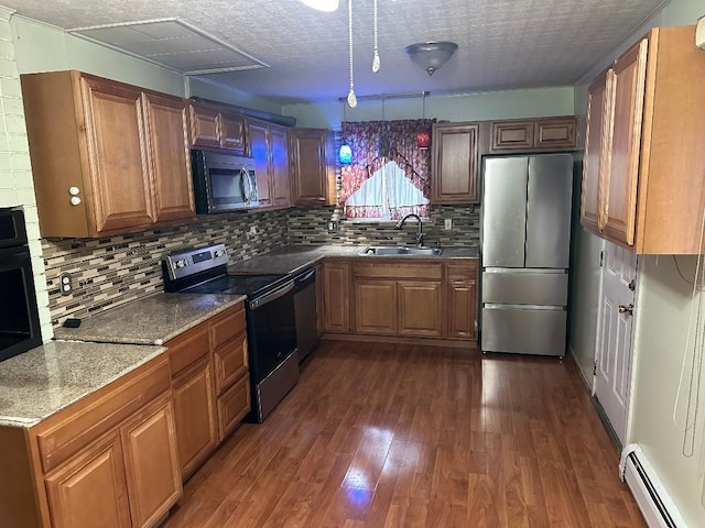 kitchen featuring sink, dark wood-type flooring, a baseboard heating unit, a textured ceiling, and black appliances