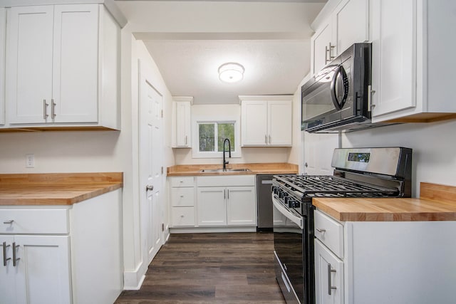 kitchen with butcher block counters, sink, white cabinets, and appliances with stainless steel finishes