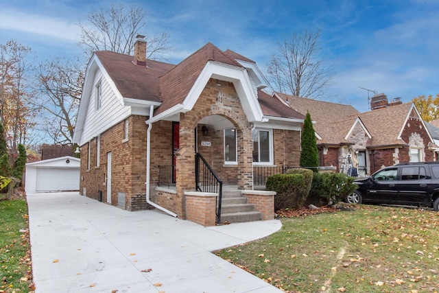 view of front of home with a garage, an outbuilding, and a front lawn