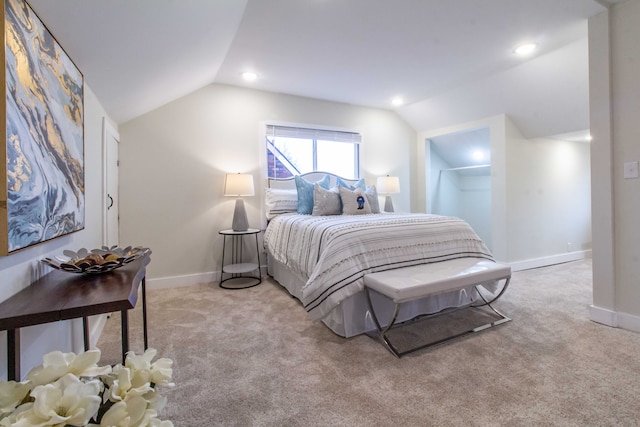 bedroom with a spacious closet, a closet, light colored carpet, and lofted ceiling