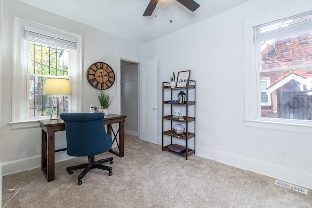 carpeted office space with ceiling fan