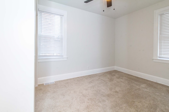 spare room featuring light colored carpet and ceiling fan