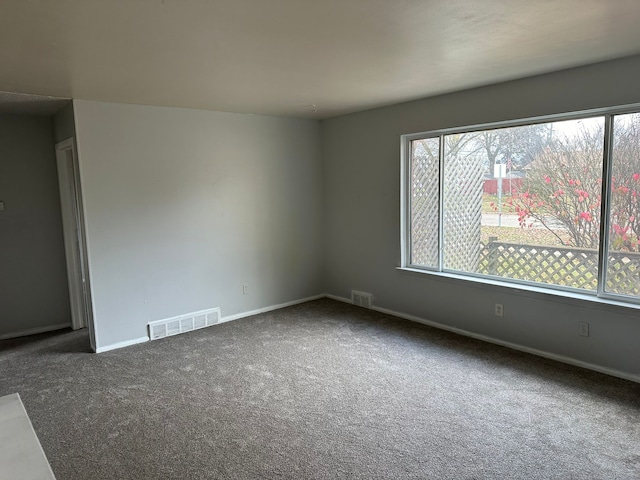 unfurnished room with dark carpet