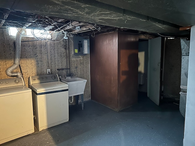 basement featuring washing machine and dryer, electric panel, and sink