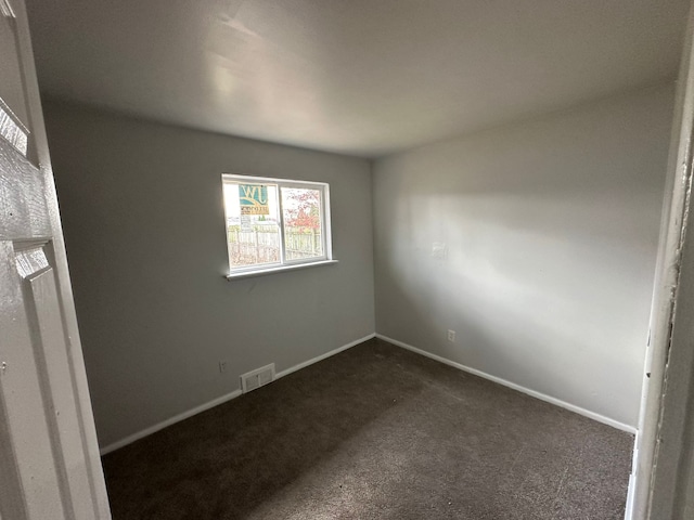 empty room featuring dark carpet