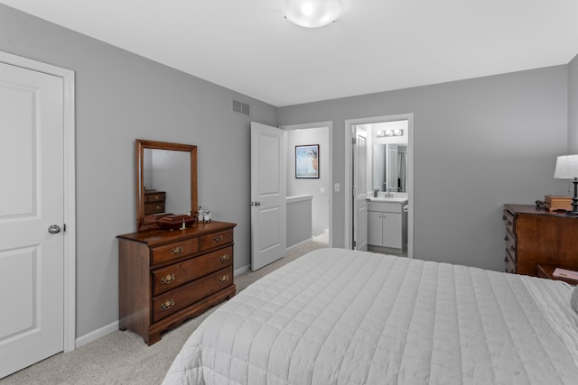 carpeted bedroom featuring ensuite bathroom and sink