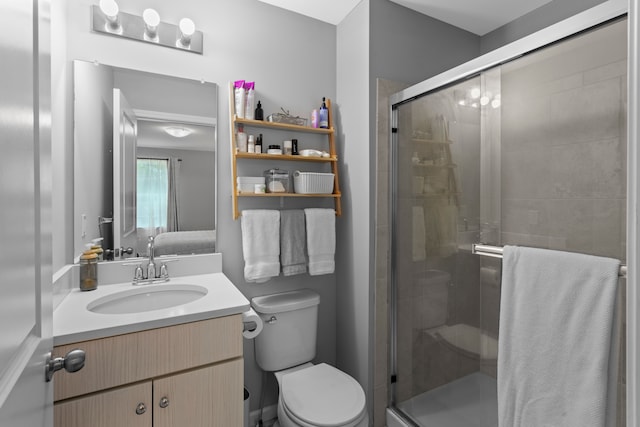 bathroom featuring an enclosed shower, vanity, and toilet