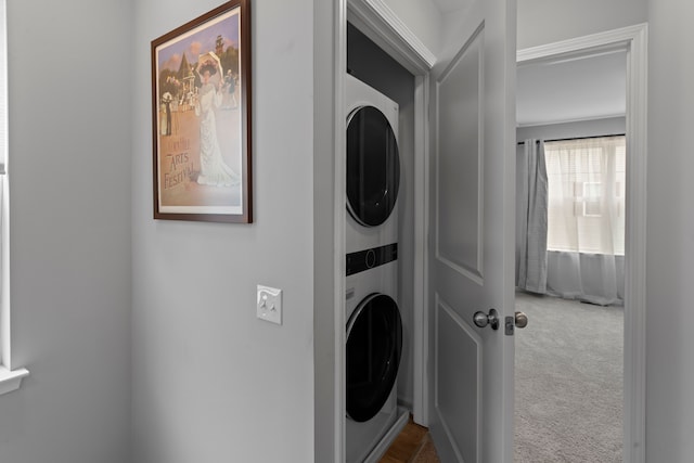 laundry room with carpet flooring and stacked washer / dryer