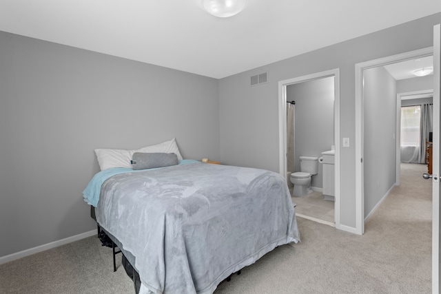 bedroom with light carpet and connected bathroom