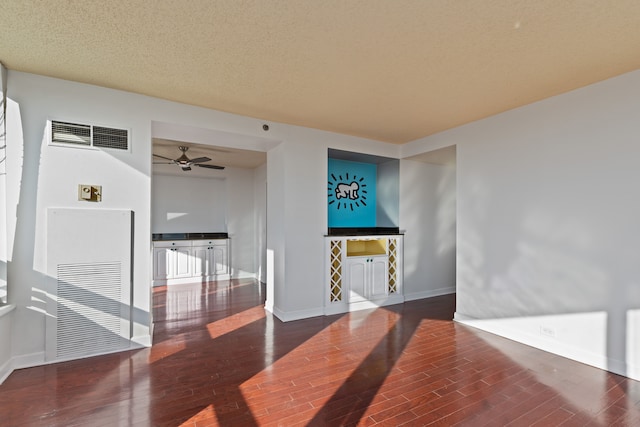 unfurnished room featuring a textured ceiling, ceiling fan, and dark hardwood / wood-style floors
