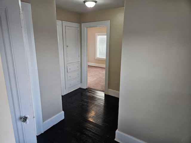 corridor with dark hardwood / wood-style flooring