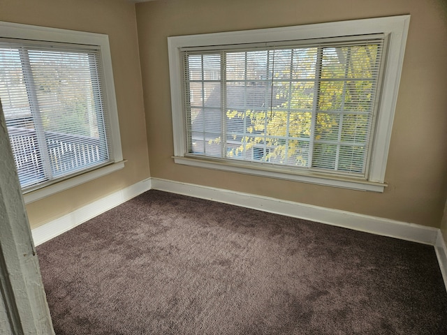 spare room featuring dark carpet