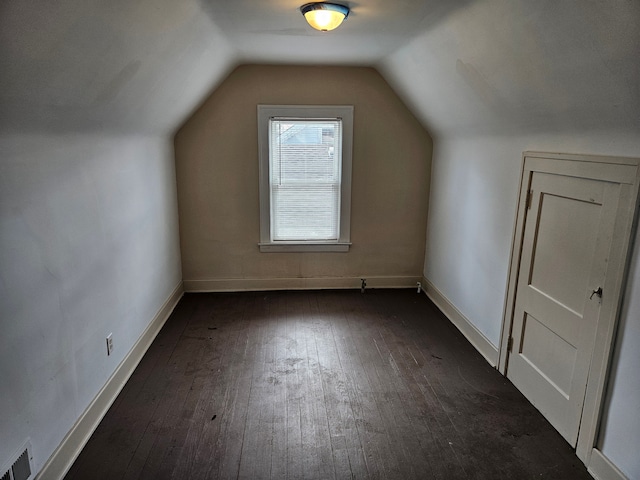 additional living space with dark hardwood / wood-style floors and vaulted ceiling