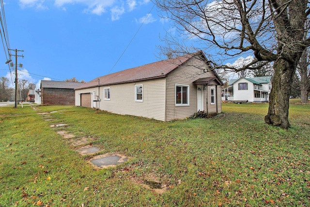 view of side of property featuring a yard and a garage