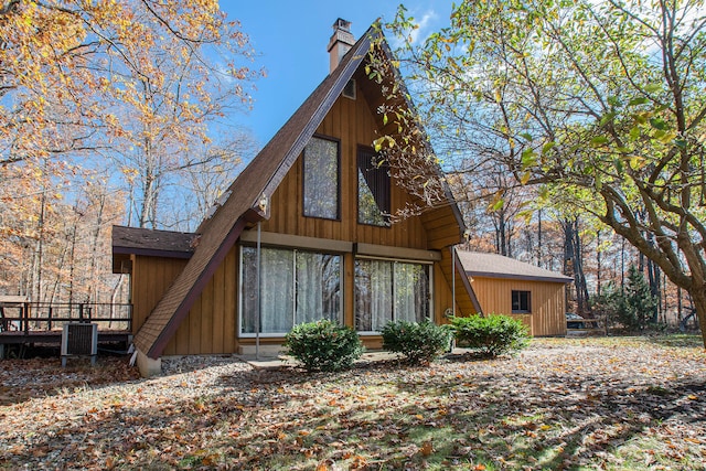 back of house featuring central air condition unit and a wooden deck