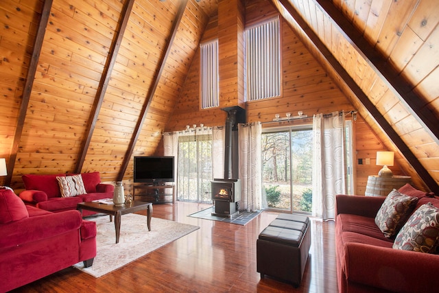 living room featuring hardwood / wood-style floors, wooden ceiling, a wood stove, and wooden walls