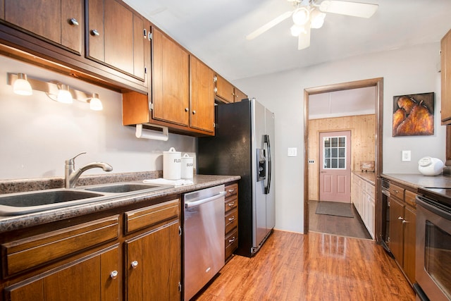 kitchen with ceiling fan, sink, appliances with stainless steel finishes, and light hardwood / wood-style flooring