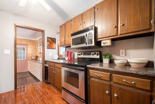 kitchen featuring ornamental molding, stainless steel appliances, ceiling fan, dark wood-type flooring, and wine cooler