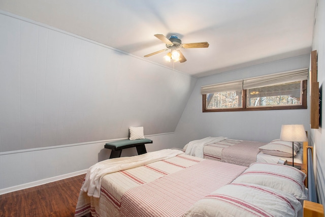 bedroom with vaulted ceiling, ceiling fan, and dark wood-type flooring