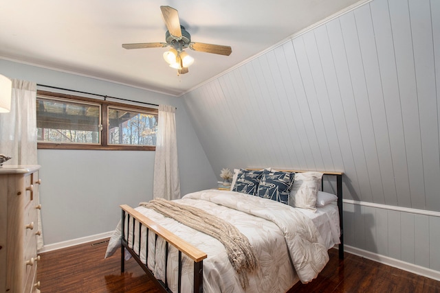 bedroom featuring ceiling fan, ornamental molding, dark wood-type flooring, and wooden walls