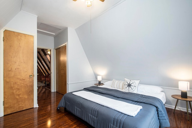 bedroom featuring ceiling fan, a closet, dark wood-type flooring, and lofted ceiling