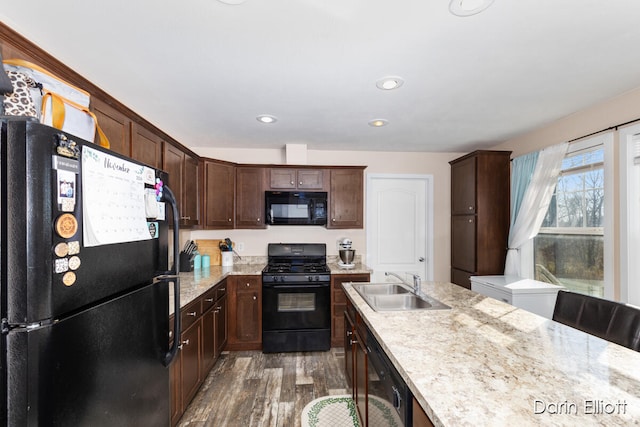 kitchen featuring black appliances, sink, dark hardwood / wood-style floors, light stone countertops, and dark brown cabinets