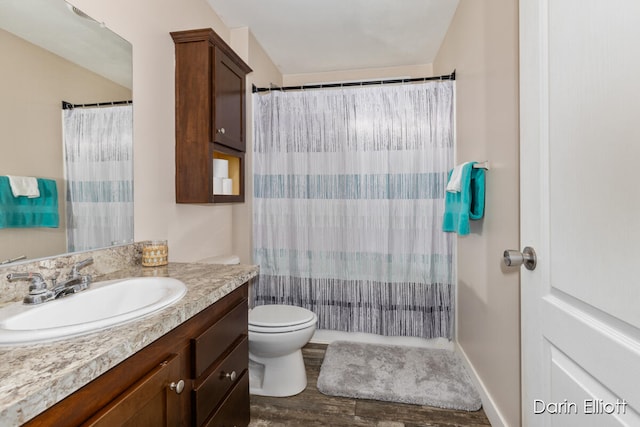 bathroom featuring hardwood / wood-style floors, vanity, toilet, and walk in shower