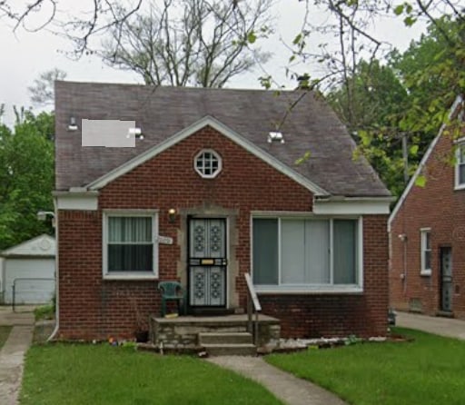 view of front of house featuring a front yard, a garage, and an outdoor structure