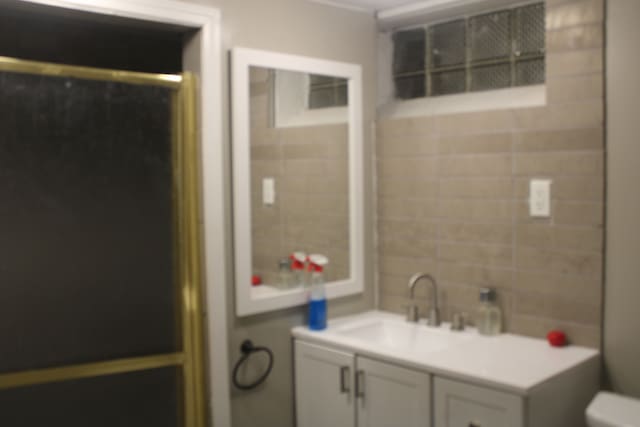 bathroom with vanity, toilet, and a shower with shower door