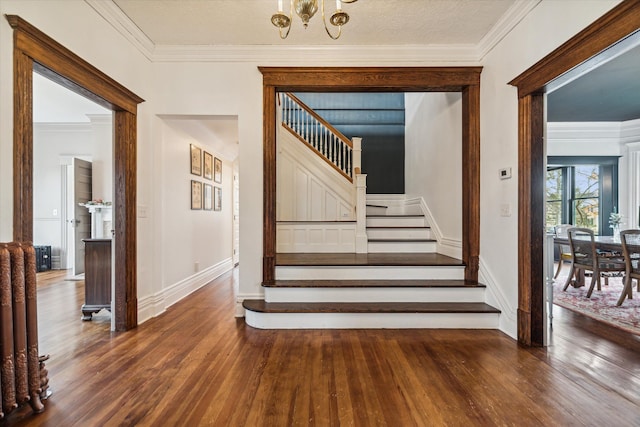 stairs with hardwood / wood-style floors, a textured ceiling, ornamental molding, and a notable chandelier