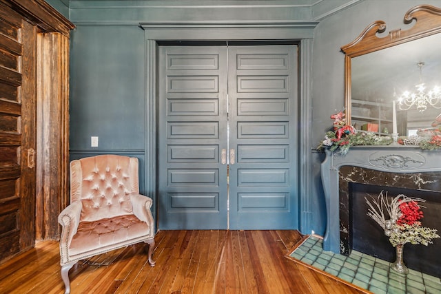 foyer entrance with wood-type flooring, an inviting chandelier, and crown molding