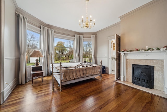 bedroom with hardwood / wood-style floors, an inviting chandelier, crown molding, and multiple windows