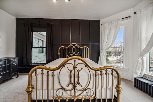 bedroom with radiator heating unit and light colored carpet