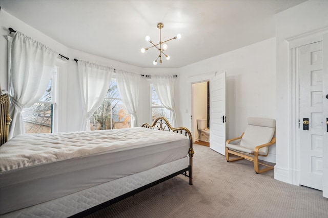 bedroom featuring a chandelier, carpet floors, and ensuite bathroom