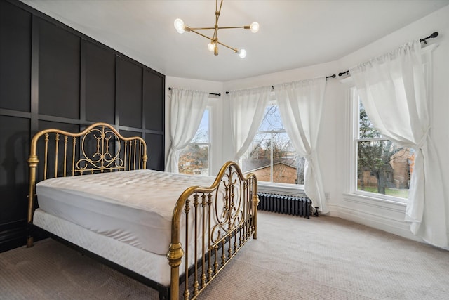 bedroom featuring multiple windows, light carpet, radiator heating unit, and a chandelier