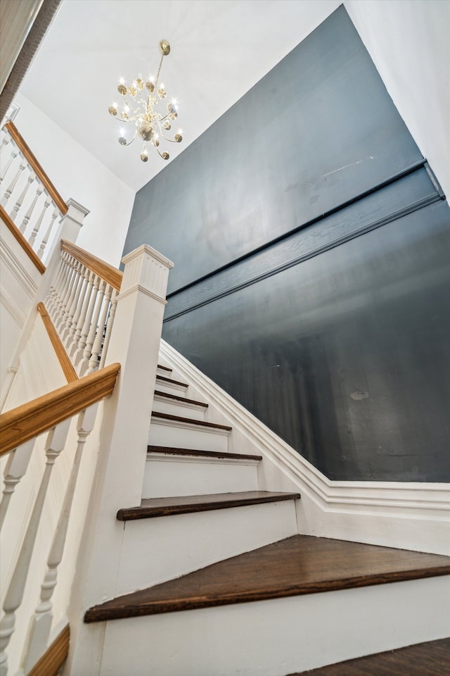 stairway featuring hardwood / wood-style floors and a chandelier