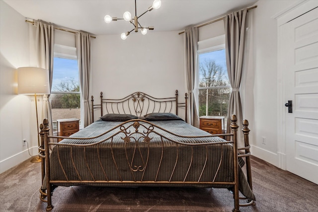 bedroom featuring a chandelier and dark carpet