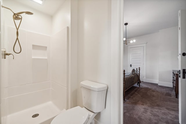 bathroom with toilet, a shower, and an inviting chandelier