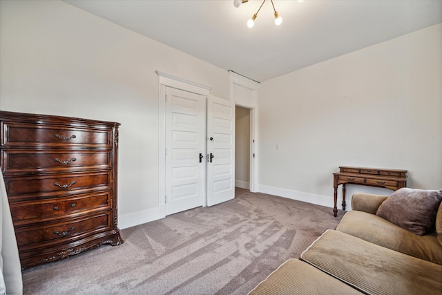 sitting room featuring light carpet and an inviting chandelier