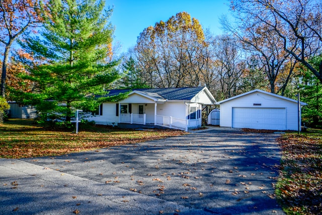 ranch-style home with covered porch, a garage, a front lawn, and an outdoor structure