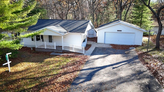 ranch-style home with an outdoor structure, a porch, and a garage