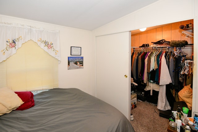 bedroom featuring carpet flooring, lofted ceiling, a closet, and wooden walls