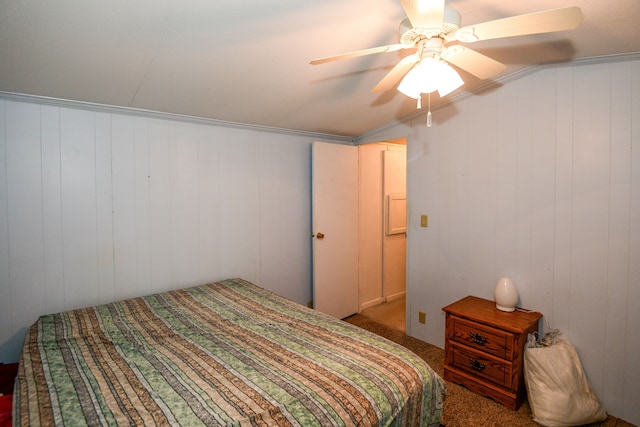 carpeted bedroom with ceiling fan, crown molding, and wood walls