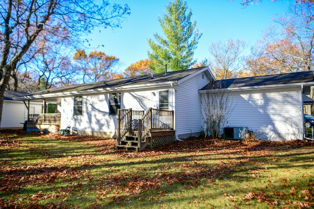 rear view of property featuring a lawn and a deck