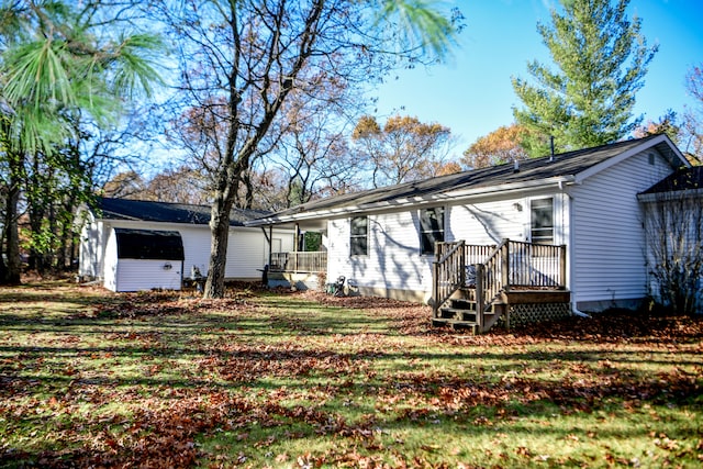 rear view of property with a lawn and a storage shed