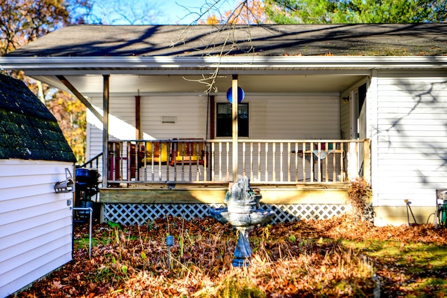 rear view of house featuring covered porch